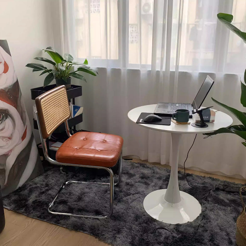 Una silla de comedor ergonómica hecha de ratán, con asas y asiento ajustable, perfecta para uso en patio y hogar. Se utiliza manualmente, tiene un respaldo robusto y es fácil de limpiar localmente, lo que la hace adecuada para adultos y ideal para suelos