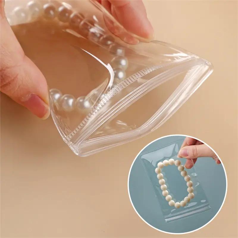 50/100 bolsas transparentes con cierre hermético de PVC, bolsas para joyería, resistentes al polvo y la oxidación, para guardar aretes, anillos, collares, pulseras, dijes y artículos pequeños, 2 tamaños a elegir (Cajas y organizadores de joyería)