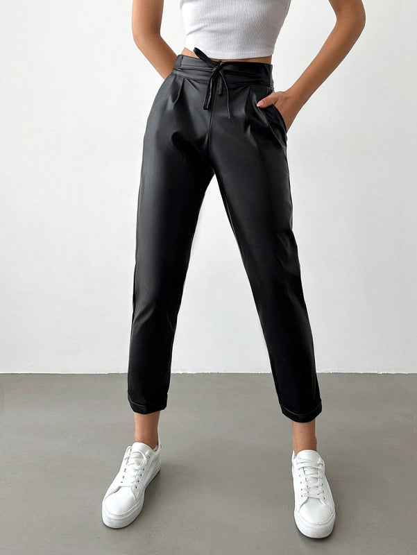 Pantalones largos de tela metalica con nudo frontal para mujer