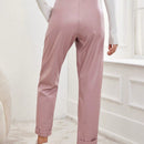 Pantalones largos de tela metalica con nudo frontal para mujer
