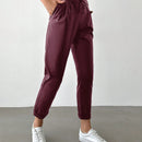 Pantalones largos de tela metalica con nudo frontal para mujer