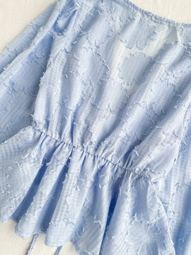 Camisa romantica de manga larga con cuello en V, dobladillo con volantes, mangas de campana y nudo al frente. Perfecta para vacaciones y ropa casual