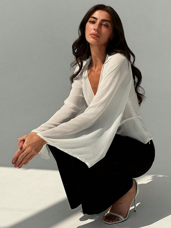 Blusa blanca de mujer con cuello en V profundo transparente, mangas largas abocinadas y munequeras con cintura suelta