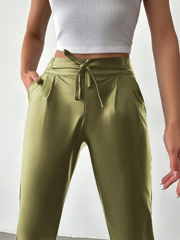 Pantalones largos de tela metalica con nudo frontal para mujer