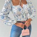 Blusa con estampado floral, manga de linterna y nudo delantero