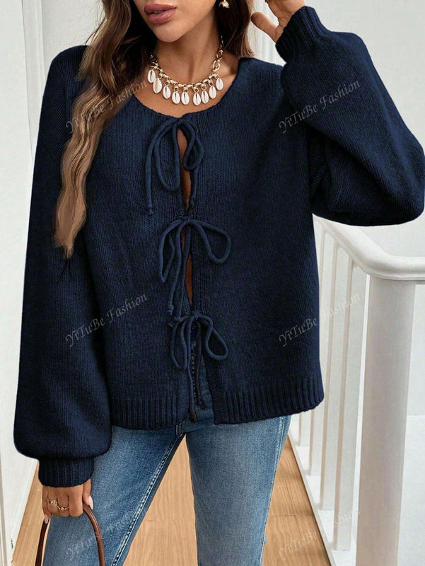 Cardigan de punto de color liso con detalle de nudo delantero, de estilo minimalista para uso en la oficina, atemporal y femenino. cardigan de punto en un solo color con abertura frontal que se puede usar sobre blusas, un cardigan oversize y adorable