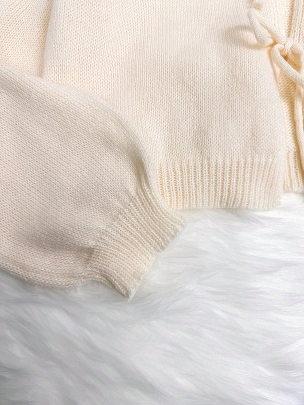 Cardigan de punto de color liso con detalle de nudo delantero, de estilo minimalista para uso en la oficina, atemporal y femenino. cardigan de punto en un solo color con abertura frontal que se puede usar sobre blusas, un cardigan oversize y adorable