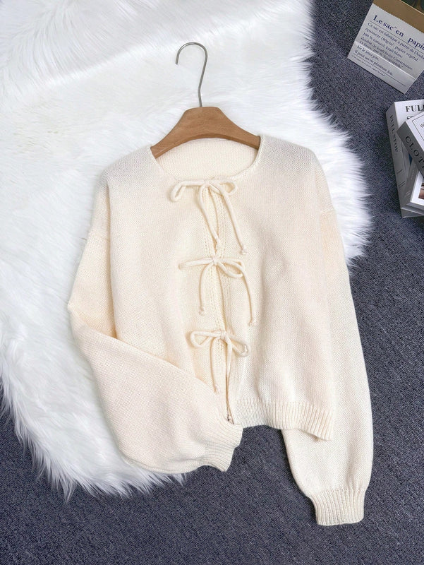 Cardigan de punto de color liso con detalle de nudo delantero, de estilo minimalista para uso en la oficina, atemporal y femenino. cardigan de punto en un solo color con abertura frontal que se puede usar sobre blusas, un cardigan oversize y adorable