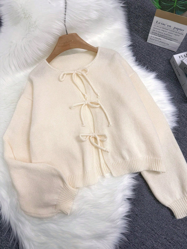 Cardigan de punto de color liso con detalle de nudo delantero, de estilo minimalista para uso en la oficina, atemporal y femenino. cardigan de punto en un solo color con abertura frontal que se puede usar sobre blusas, un cardigan oversize y adorable
