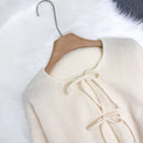 Cardigan de punto de color liso con detalle de nudo delantero, de estilo minimalista para uso en la oficina, atemporal y femenino. cardigan de punto en un solo color con abertura frontal que se puede usar sobre blusas, un cardigan oversize y adorable