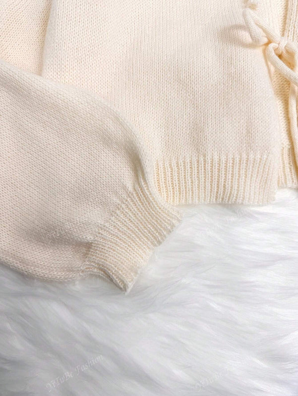 Cardigan de punto de color liso con detalle de nudo delantero, de estilo minimalista para uso en la oficina, atemporal y femenino. cardigan de punto en un solo color con abertura frontal que se puede usar sobre blusas, un cardigan oversize y adorable