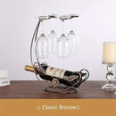 Soporte de botella de vino vintage y vaso con diseño metálico ornamentado - Alberga 1 botella y 4 vasos con tallo, ideal para decoración del hogar, fiestas y regalos de vacaciones, decoración de botella de vino.