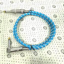 Un cable de audio grueso de 6,35 mm con un conector de ángulo derecho a un conector recto de 6,35 mm.