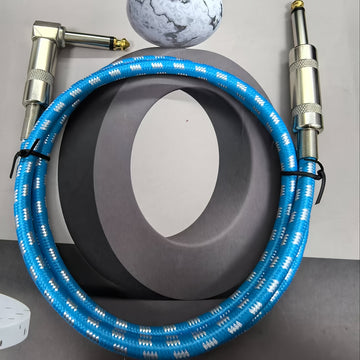 Un cable de audio grueso de 6,35 mm con un conector de ángulo derecho a un conector recto de 6,35 mm.