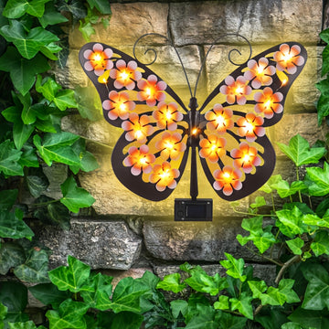 Una lámpara de pared con forma de mariposa, una luz decorativa con silueta de mariposa de arte de hierro con energía solar, adecuada para jardines al aire libre, patios y decoraciones festivas de primavera en paredes exteriores.