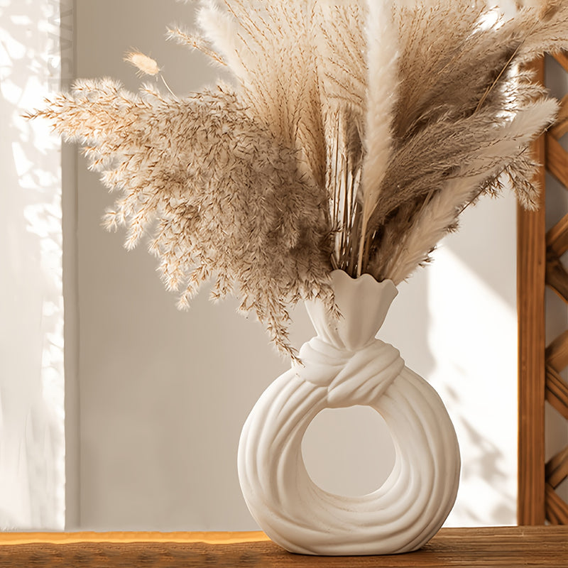 Una botella decorativa de resina, ideal para decoración de hogar contemporáneo, un jarrón minimalista nórdico bohemio para flores de pampa, con un diseño distintivo de lazo, apto para uso como jarrón o como regalo decorativo.