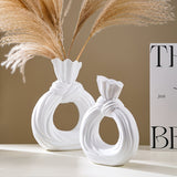 Una botella decorativa de resina, ideal para decoración de hogar contemporáneo, un jarrón minimalista nórdico bohemio para flores de pampa, con un diseño distintivo de lazo, apto para uso como jarrón o como regalo decorativo.