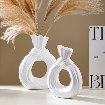Una botella decorativa de resina, ideal para decoración de hogar contemporáneo, un jarrón minimalista nórdico bohemio para flores de pampa, con un diseño distintivo de lazo, apto para uso como jarrón o como regalo decorativo.