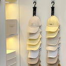 Una caja de almacenamiento para gorras de béisbol con clips, con ocho clips y capacidad para sostener 16 gorras en un estante, junto con ganchos para colgar gorras.