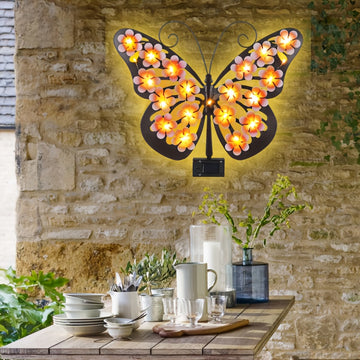 Una lámpara de pared con forma de mariposa, una luz decorativa con silueta de mariposa de arte de hierro con energía solar, adecuada para jardines al aire libre, patios y decoraciones festivas de primavera en paredes exteriores.