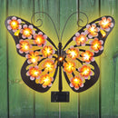 Una lámpara de pared con forma de mariposa, una luz decorativa con silueta de mariposa de arte de hierro con energía solar, adecuada para jardines al aire libre, patios y decoraciones festivas de primavera en paredes exteriores.